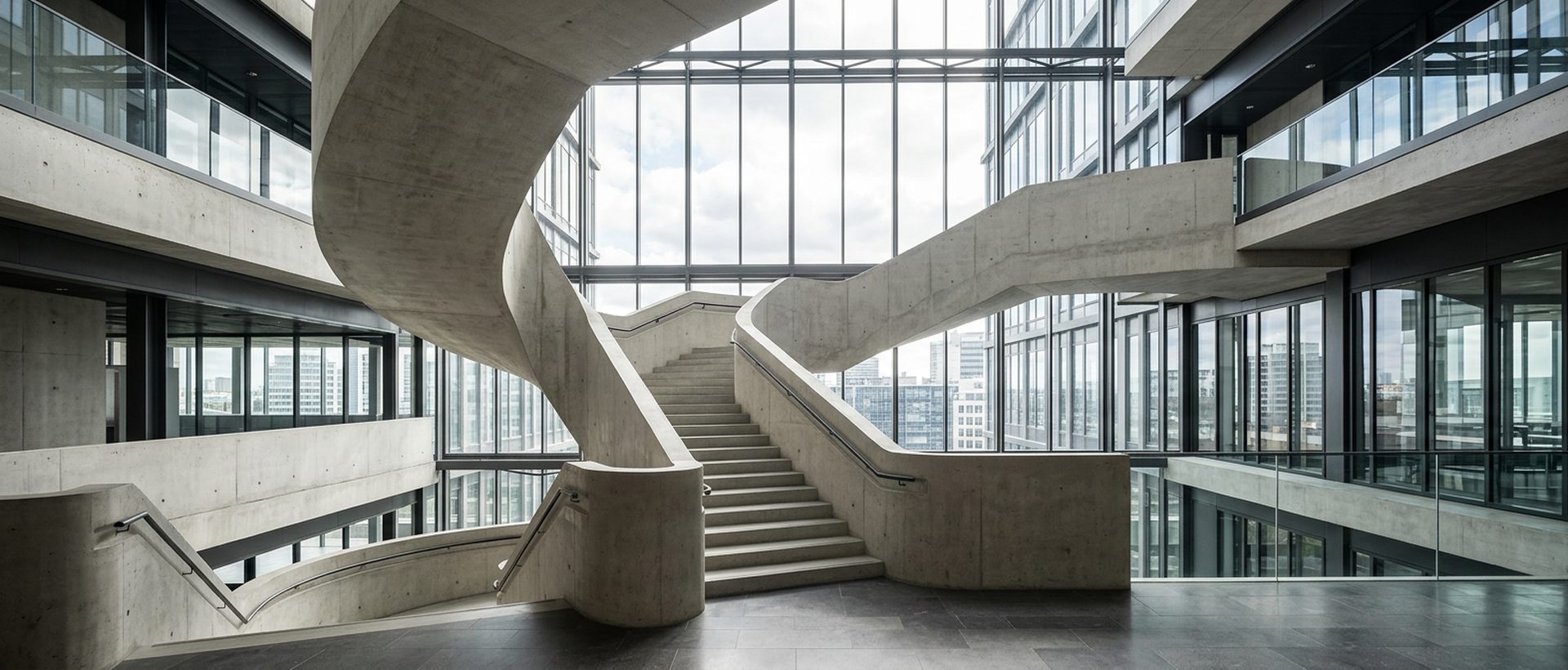 Escalier monumental en béton clair dans un immeuble tertiaire, contre-jour