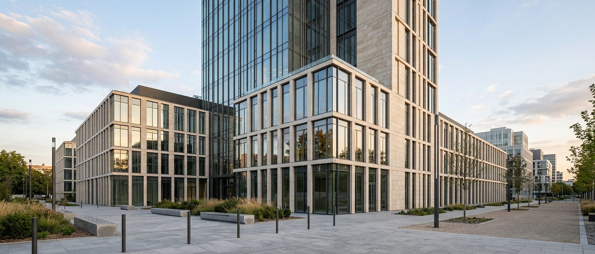 Immeuble de bureaux contemporain en verre et pierre claire, façade rythmée, lumière de fin d'après-midi