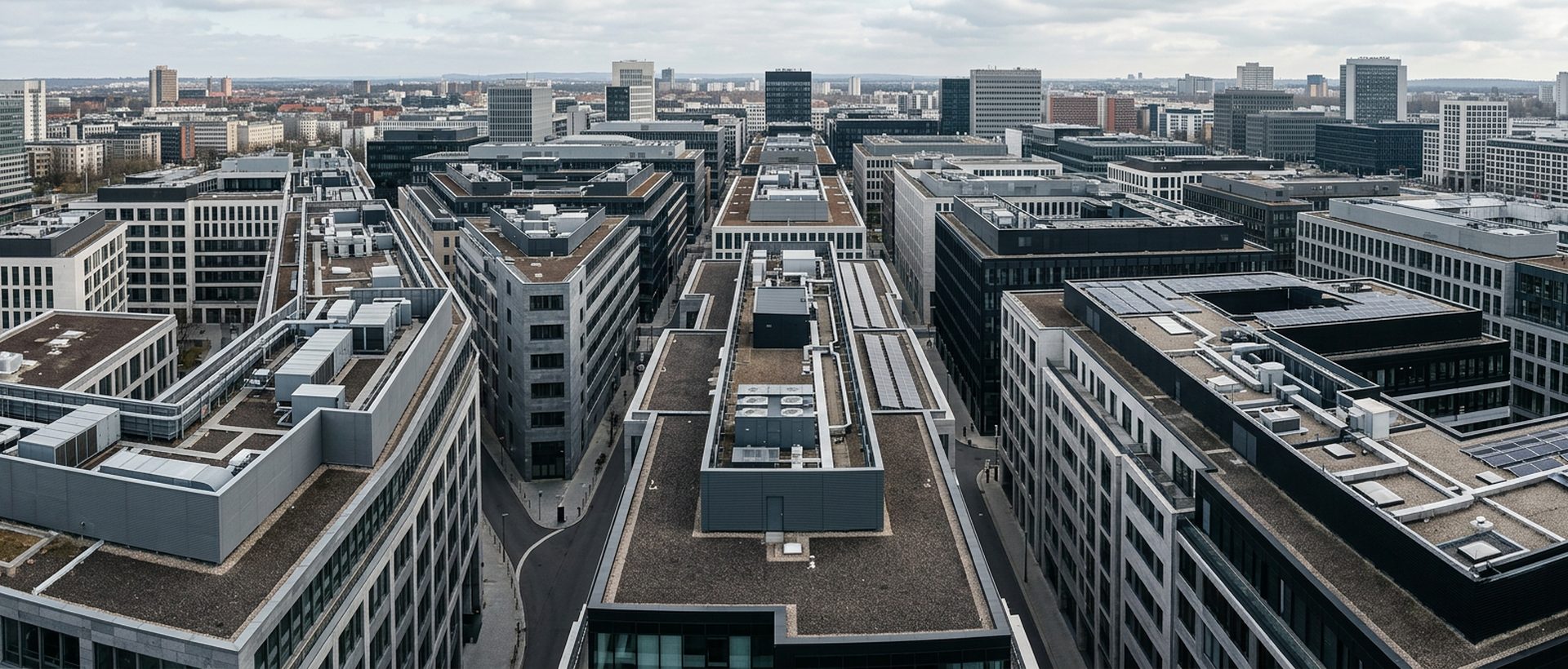 Vue plongeante sur un ensemble de toitures d'immeubles tertiaires, géométrie régulière